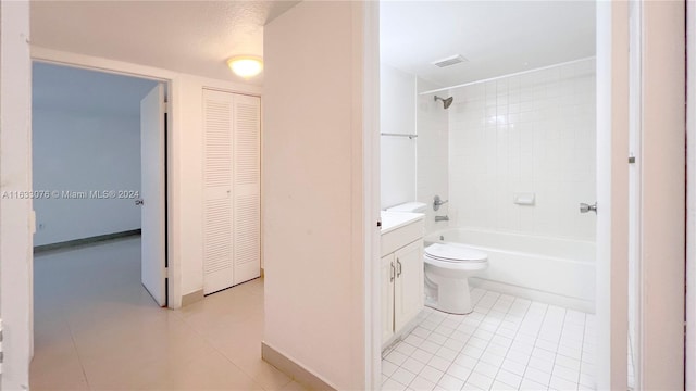 full bathroom with tile patterned floors, tiled shower / bath, vanity, and toilet