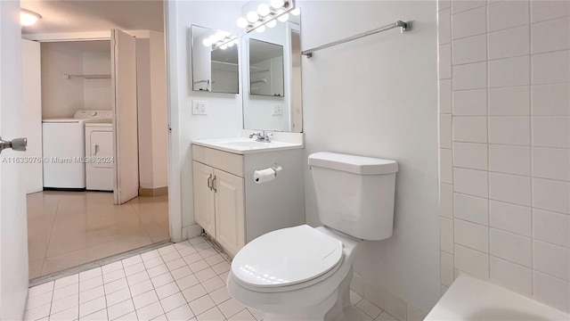 bathroom featuring tile patterned floors, washer and clothes dryer, toilet, and vanity