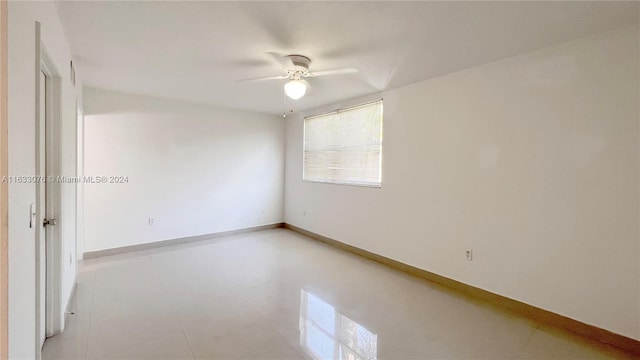 tiled empty room with ceiling fan