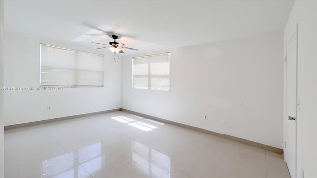 spare room featuring ceiling fan and light tile patterned floors