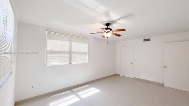 tiled empty room with ceiling fan