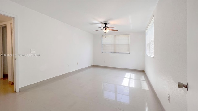 empty room featuring light tile patterned flooring and ceiling fan