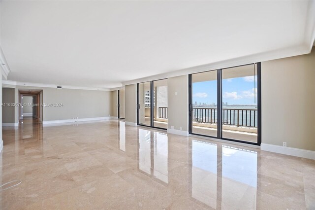 tiled spare room featuring floor to ceiling windows