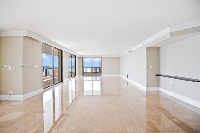 empty room with a wall of windows, ornamental molding, and light tile patterned floors