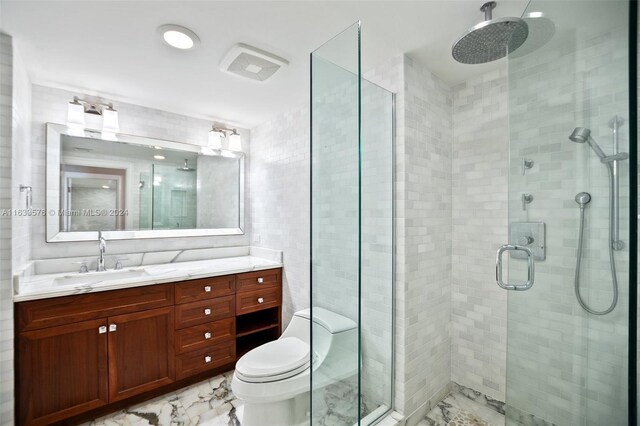 bathroom with tile patterned flooring, an enclosed shower, toilet, vanity, and tile walls