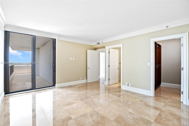 unfurnished bedroom featuring ornamental molding, a walk in closet, and baseboards