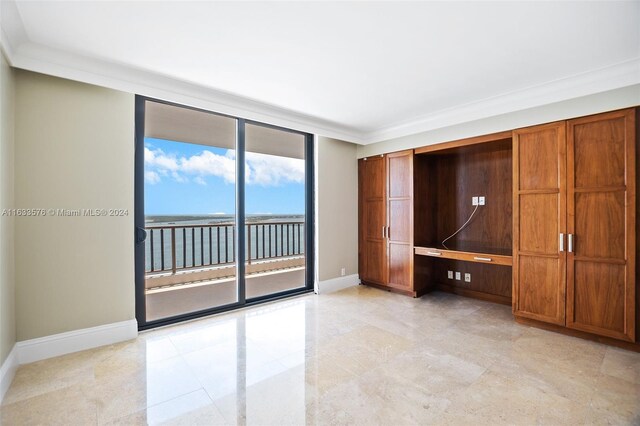 unfurnished bedroom with ornamental molding, a wall of windows, light tile patterned flooring, and access to outside