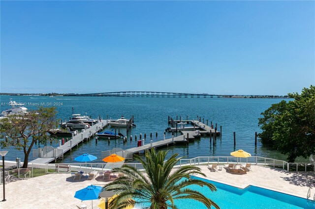 exterior space featuring a water view, a community pool, and a patio area