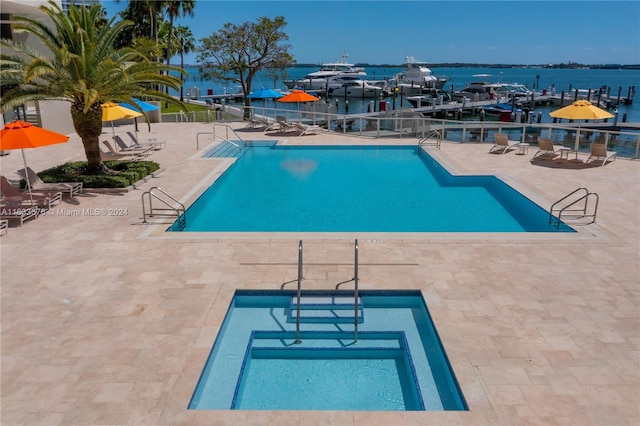 view of pool with a water view and a patio area