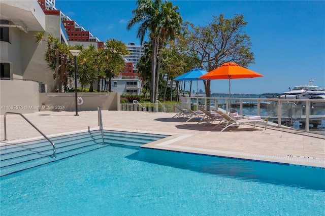 community pool with a patio area and fence