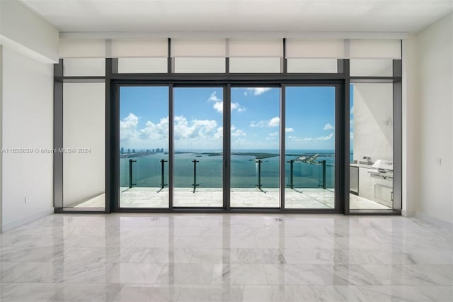 empty room featuring expansive windows and a water view