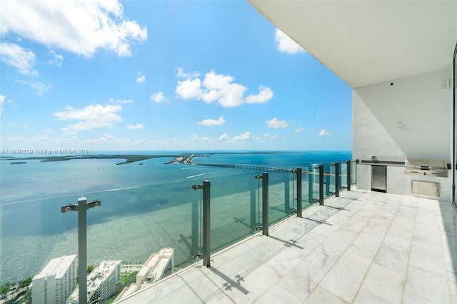 balcony featuring a water view and an outdoor kitchen