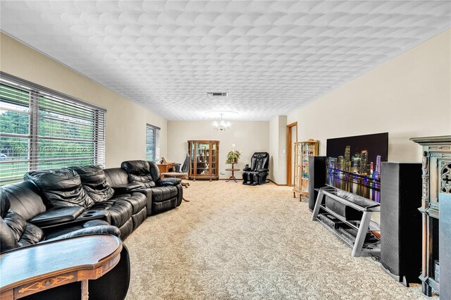 carpeted living room with a chandelier and a textured ceiling