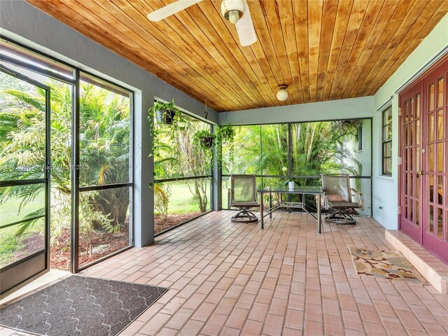 unfurnished sunroom with ceiling fan and wood ceiling