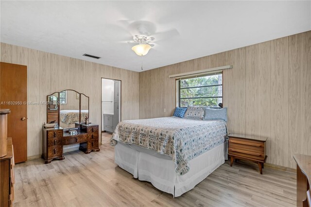 bedroom featuring ensuite bath, wood-type flooring, and ceiling fan