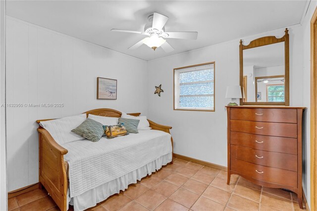 bedroom with crown molding, ceiling fan, and light tile patterned flooring