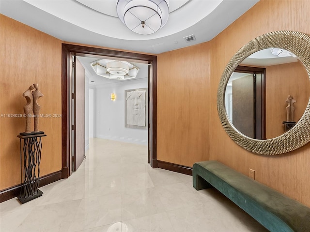 hallway featuring wood walls