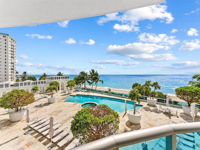 view of pool featuring a water view and a patio