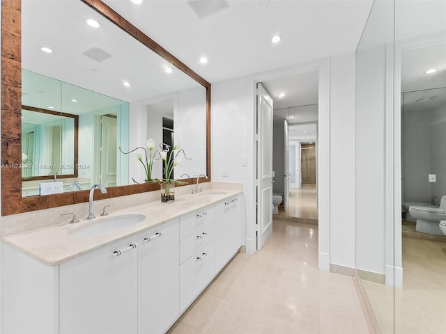 bathroom featuring tile patterned flooring, vanity, toilet, and a bidet