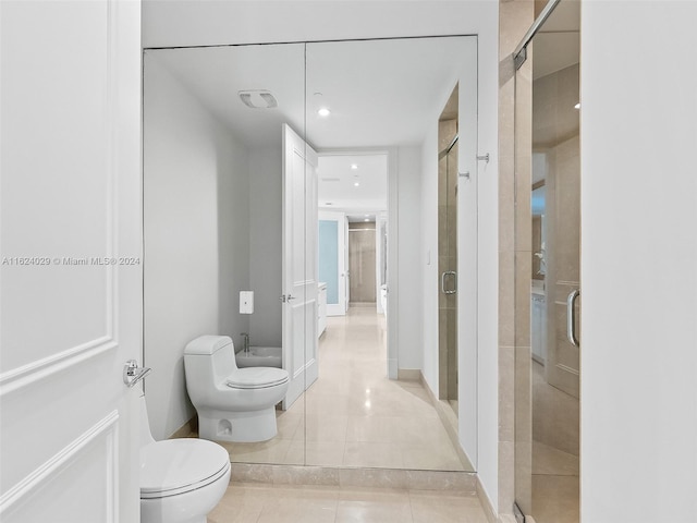 bathroom featuring walk in shower, tile patterned flooring, and toilet