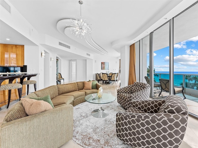 tiled living room with a water view and a notable chandelier