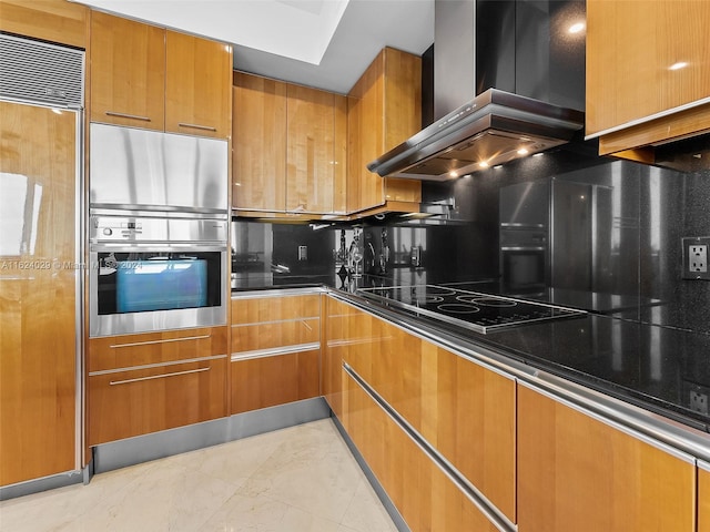 kitchen featuring stainless steel double oven, wall chimney range hood, paneled built in refrigerator, dark stone counters, and black electric cooktop