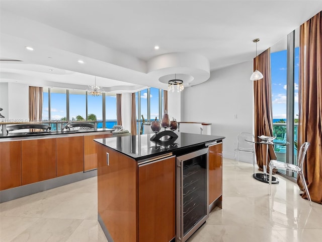 kitchen with pendant lighting, a water view, wine cooler, and a wealth of natural light