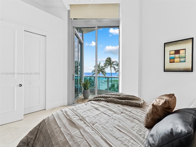 bedroom with access to exterior and a water view