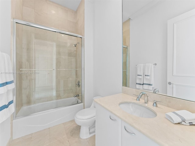 full bathroom with shower / bath combination with glass door, tile patterned floors, vanity, and toilet