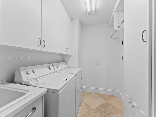 clothes washing area with cabinets, independent washer and dryer, and sink