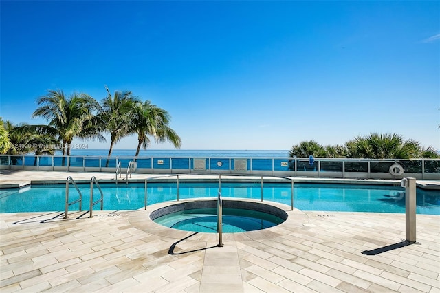 view of swimming pool featuring a community hot tub, a patio, and a water view