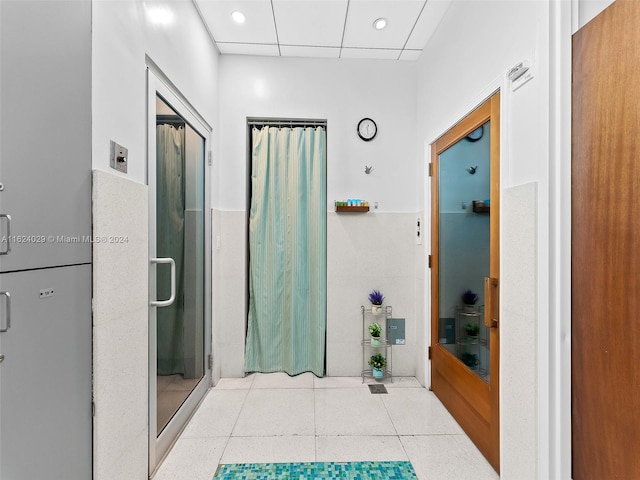 bathroom with a paneled ceiling and walk in shower