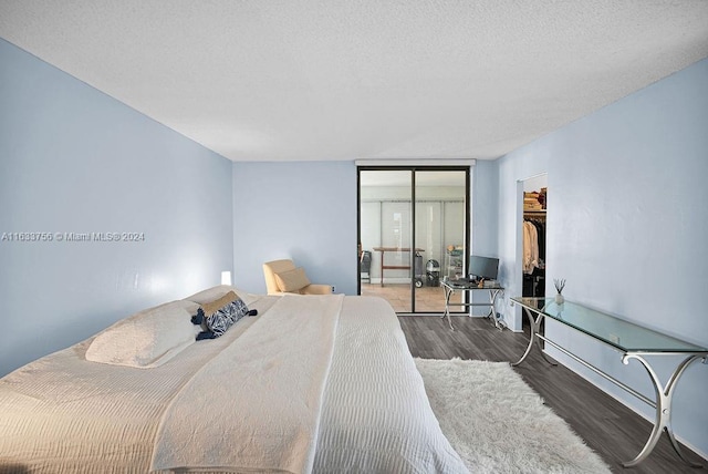 bedroom featuring dark hardwood / wood-style flooring, a closet, floor to ceiling windows, and a textured ceiling