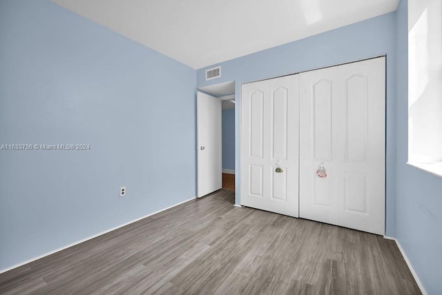 unfurnished bedroom with a closet and light hardwood / wood-style flooring