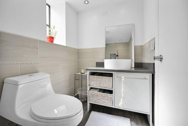 bathroom with vanity, toilet, wood-type flooring, and tile walls