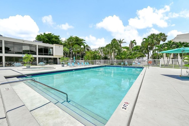 view of pool featuring a jacuzzi and a patio area