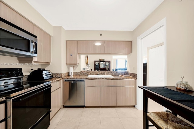 5757 Collins Ave Unit 801, Miami Beach, FL 33140 - kitchen with appliances with stainless steel finishes, light brown cabinetry, a sink, and stone counters