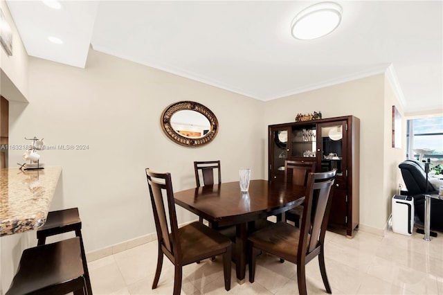 dining room with ornamental molding and light tile patterned floors