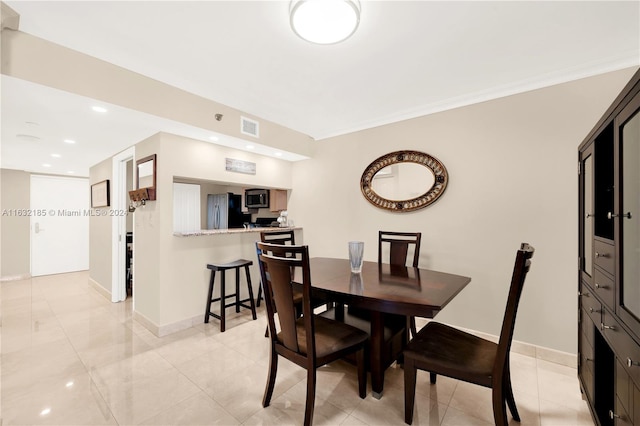 dining space with crown molding and light tile patterned floors