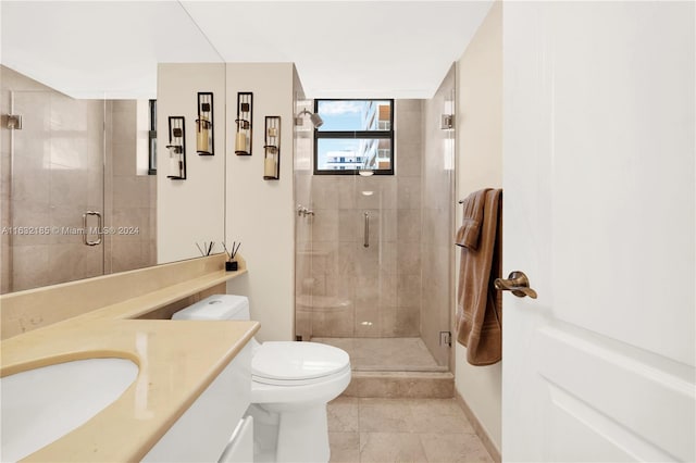 bathroom featuring a shower with shower door, vanity, tile patterned flooring, and toilet