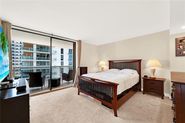 bedroom featuring expansive windows and light carpet