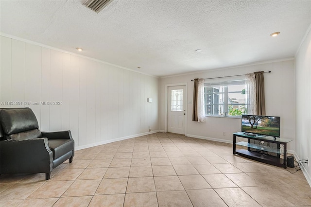 interior space with light tile patterned flooring, a textured ceiling, and crown molding