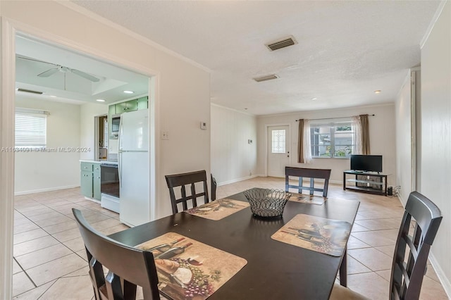 tiled dining area featuring ornamental molding and ceiling fan