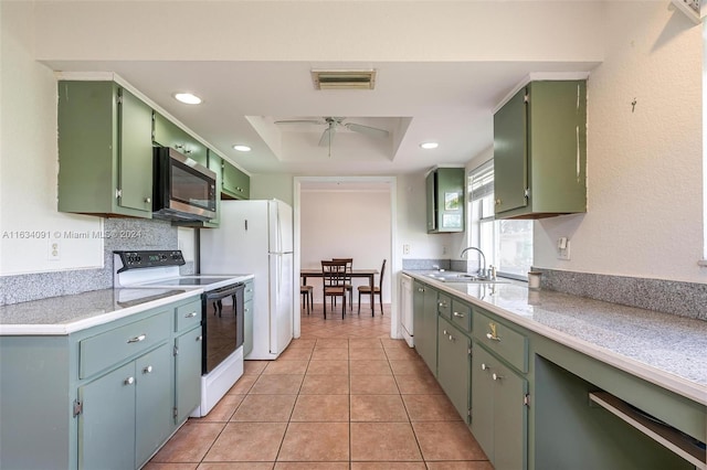 kitchen featuring a tray ceiling, sink, light tile patterned floors, white electric range, and ceiling fan