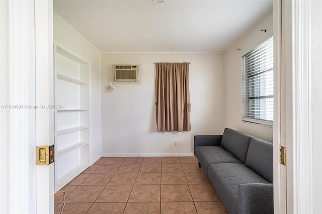 sitting room with built in features, light tile patterned flooring, and a wall unit AC