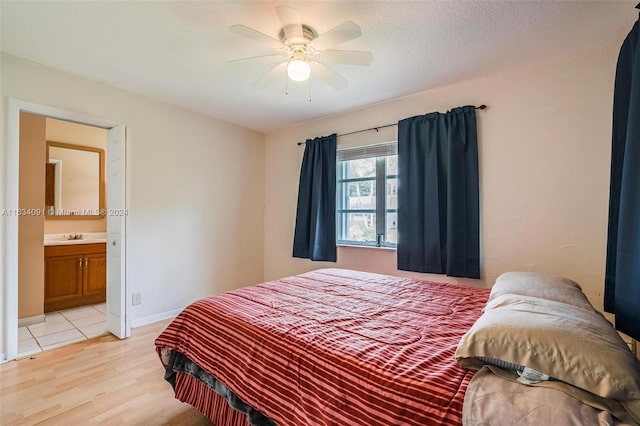 bedroom with sink, light hardwood / wood-style flooring, connected bathroom, and ceiling fan