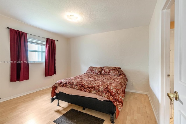 bedroom featuring a textured ceiling and light wood-type flooring