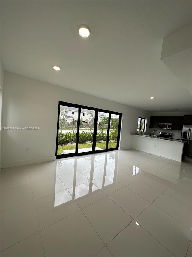 spare room with light tile patterned flooring and sink