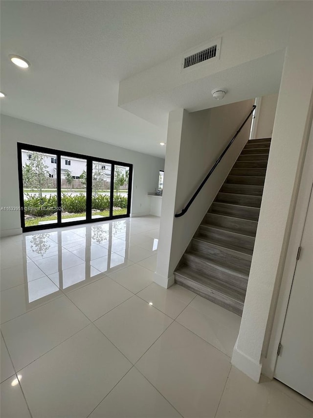 stairway with light tile patterned flooring