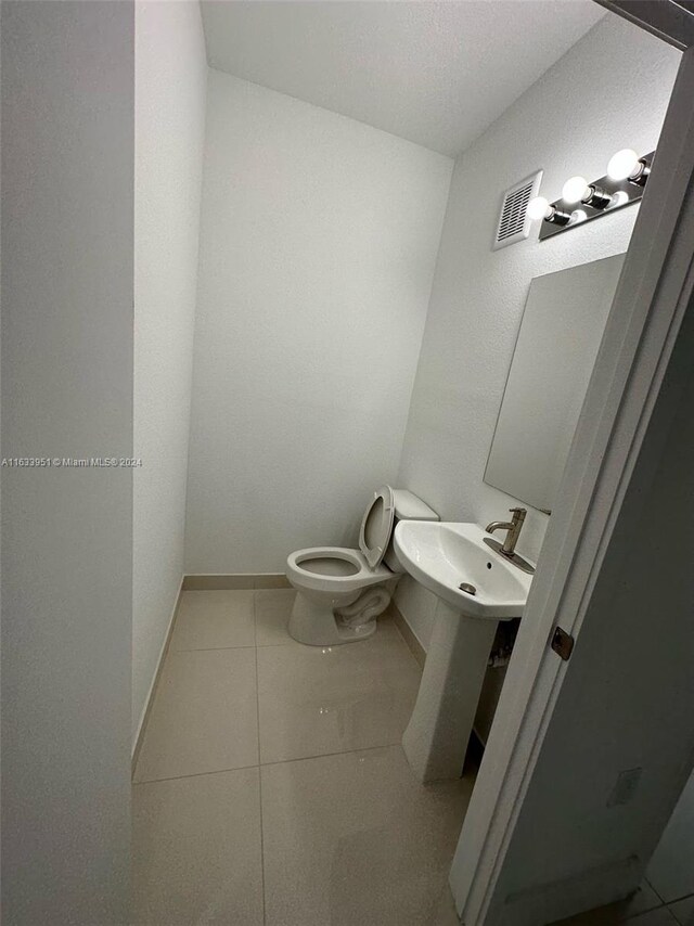 bathroom featuring sink, tile patterned flooring, and toilet